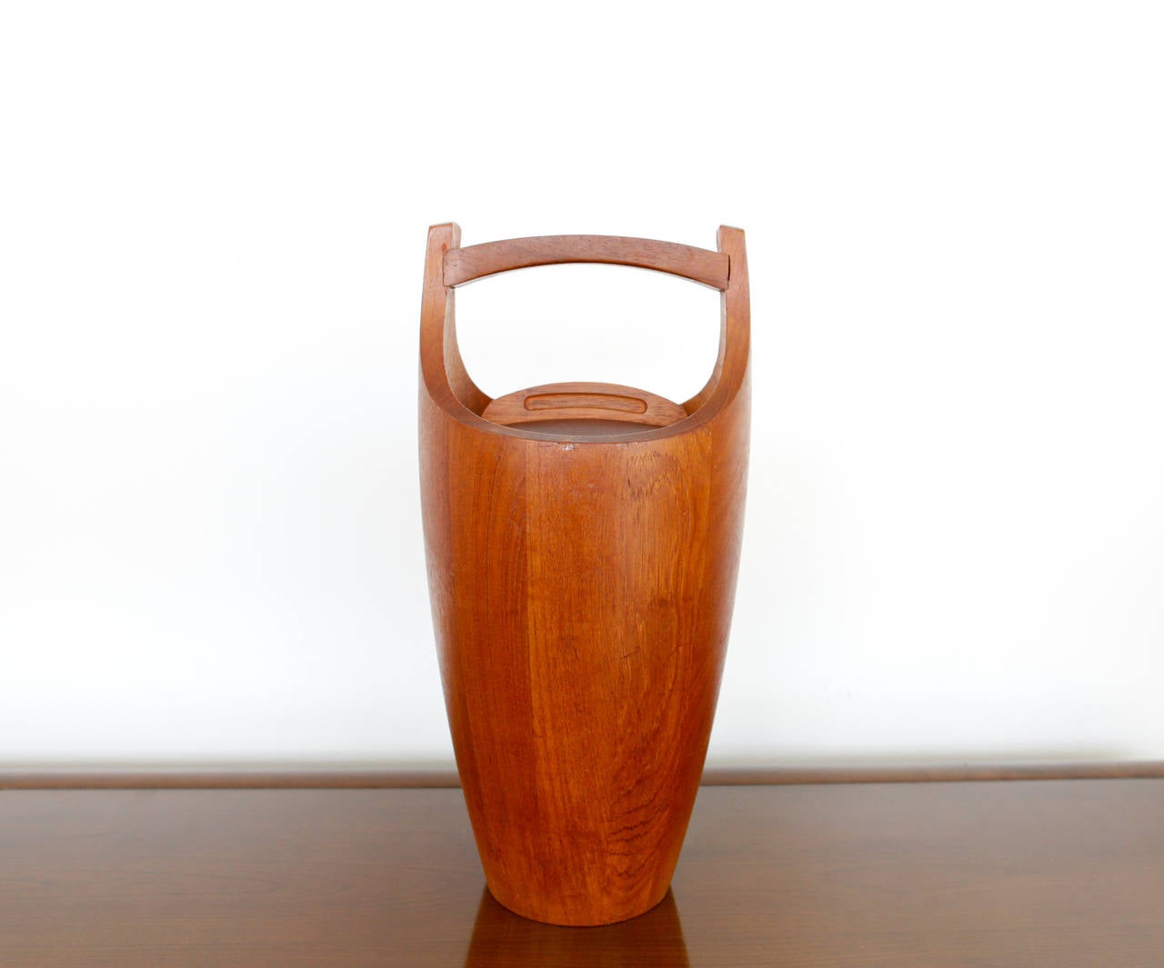 Danish modern teak ice bucket by Jens Quistgaard for Lovig, 1956.
Composed of teakwood it opens to reveal a rare orange plastic liner. Designed by Jens Quistgaard for the Lovig Company in 1956, Denmark, this piece is part of the permanent