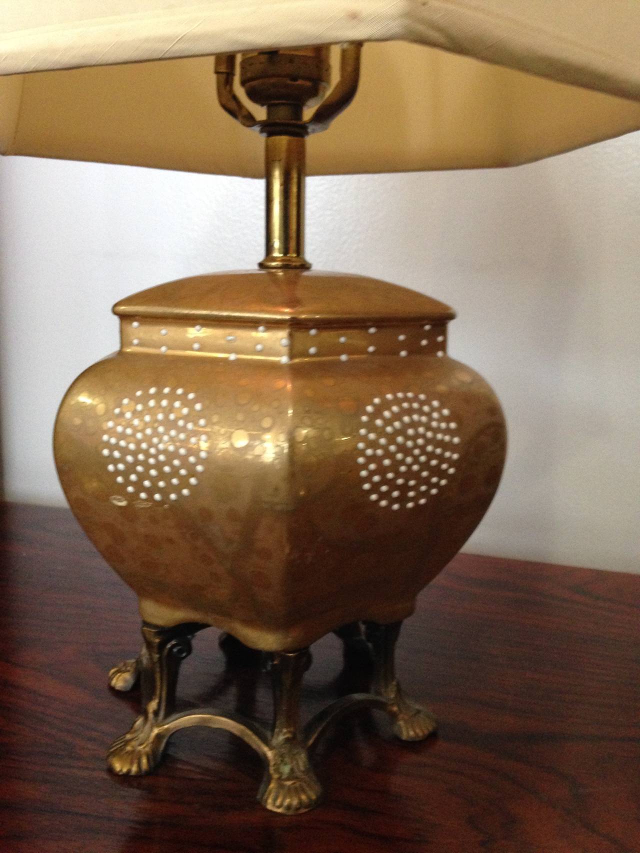 This is a beautiful and sweet little lamp. The ginger jar body is ceramic with a metallic sheen glaze and small white glaze dots atop. The base is brass metal feet. The shade is original and delightfully sized. Wonderful color.