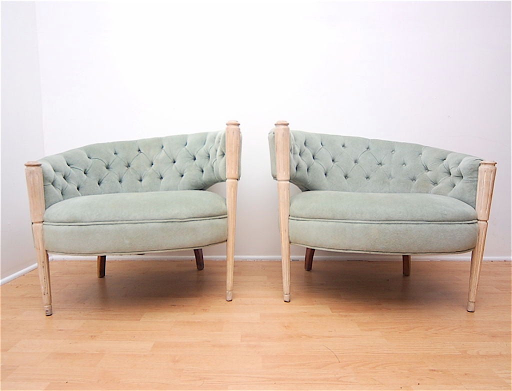 Pair of asymmetrical lounge chairs. Button tufted back.