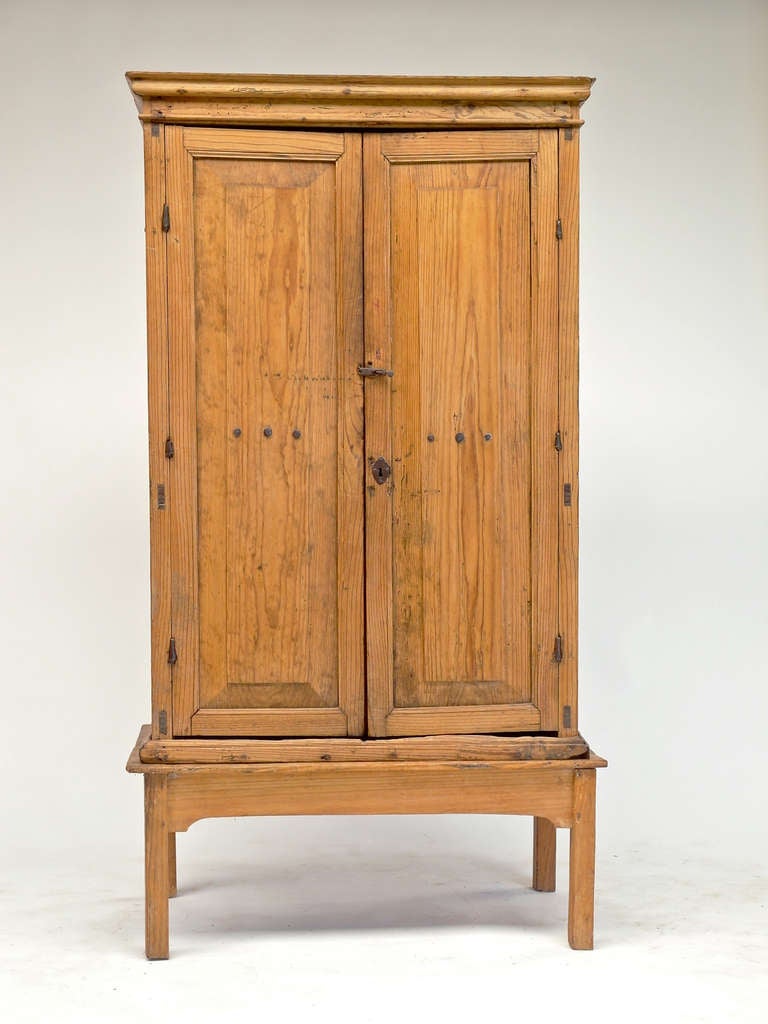 Pre 1810 Mexican colonial tall pine cabinet with handwrought iron hinges and nails based made at later date perhaps late 19th century.