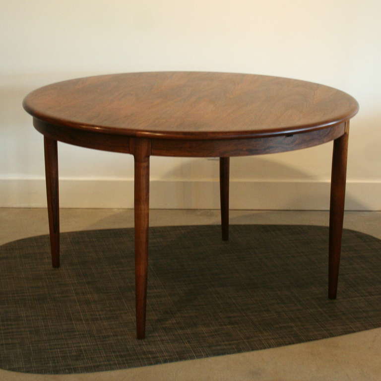 Crafted from rich Brazilian rosewood, this original Moller table is enhanced by it's stunning patina and grain detail. The table top rests on solid conical legs and has a beautiful rounded lip around the edge. Easy to expand with the butterfly leaf,