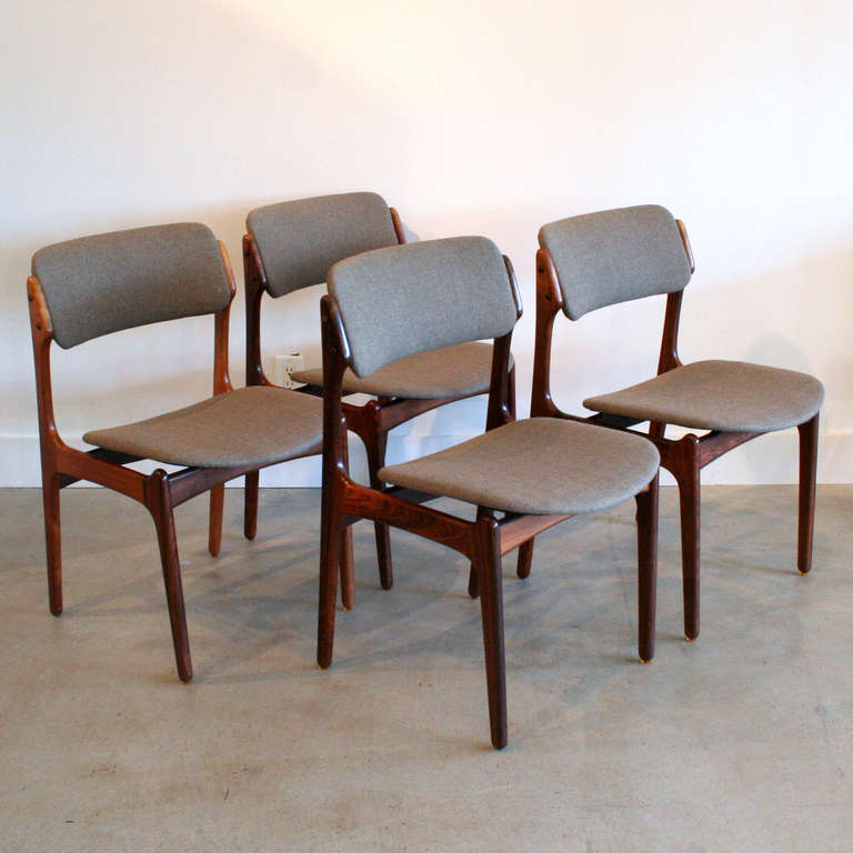 An elegant set of four dining chairs crafted in Brazilian rosewood with new tan upholstery. Upholstered and angled backrest provides extra comfort, while the seat cushion appears to float over the frame. Solid wood framing has a rich and distinctive