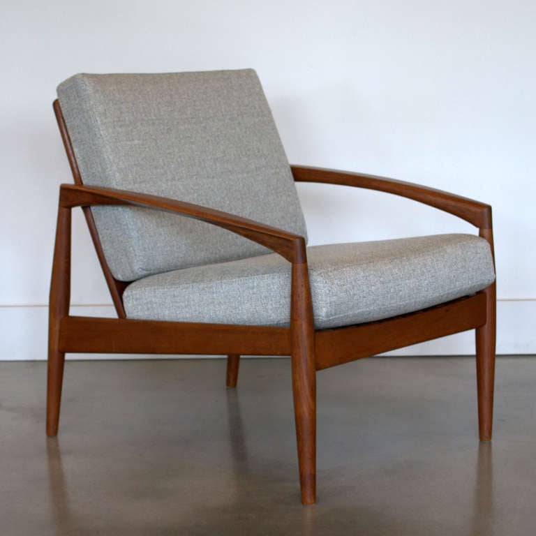 Stunning vintage solid teak lounger designed by Kai Kristiansen. The sleek design is very modern and is accentuated by the slender sloping armrests. The teak has a remarkable grain pattern. Newly reupholstered.