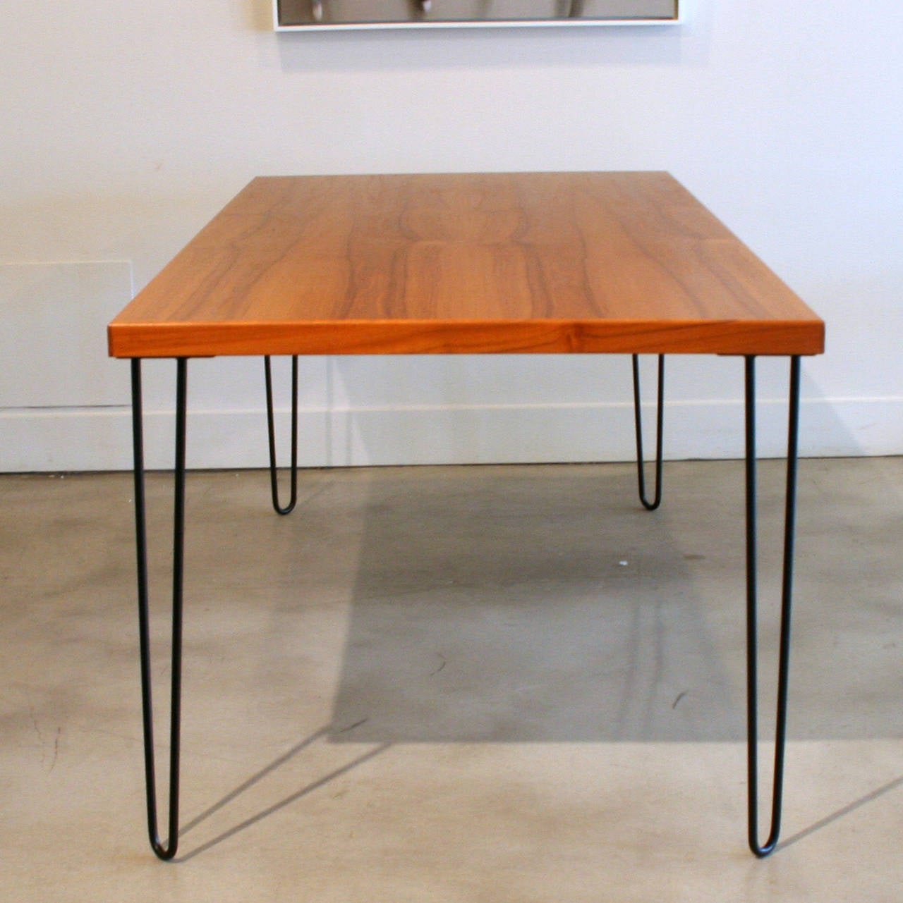 Vintage teak table top that has been reclaimed and refinished. New black metal hairpin legs have been added to create a contemporary feel. Two available.