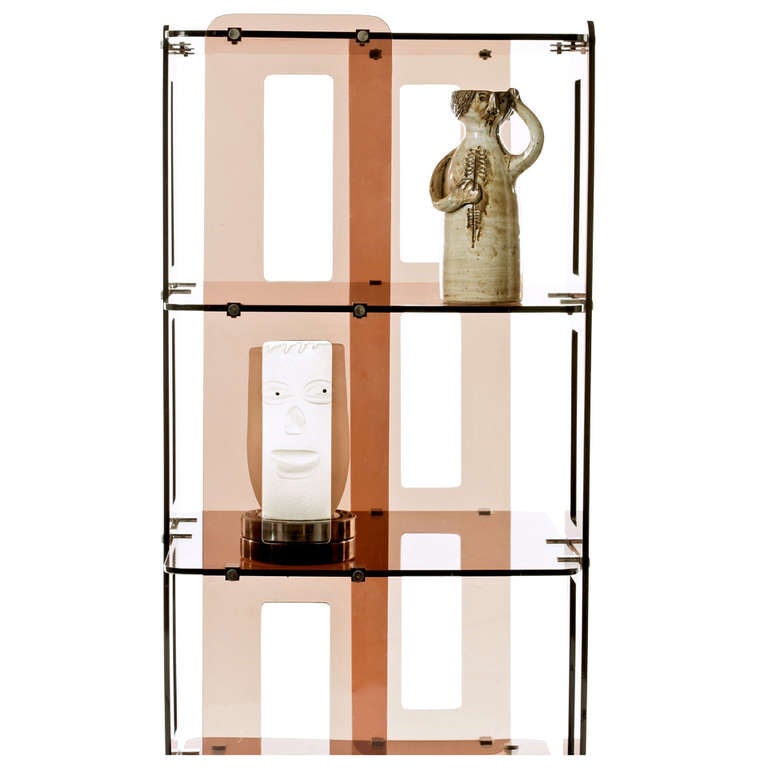Fabulous find, 1970s French revolving bookcase or decorative shelf in the manner of Boris Tabacoff or Michel Dumas in a smoky topaz Lucite with nickel hardware.