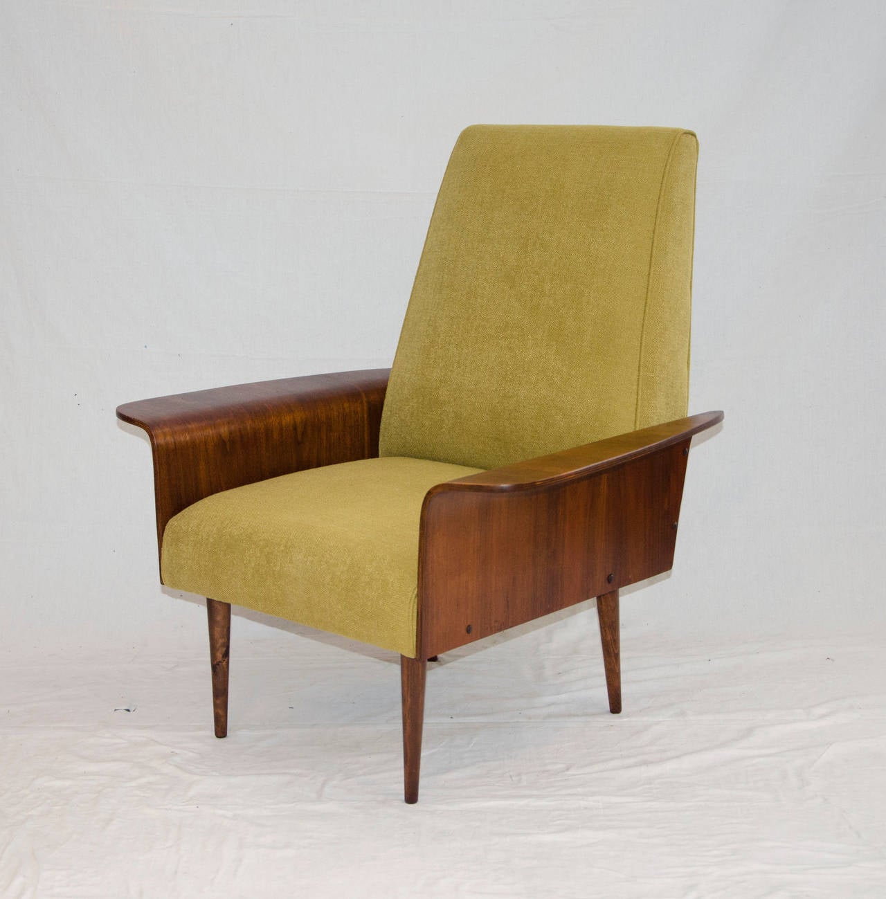 Unusual Mid-Century walnut bent ply tall back lounge chair in the style of George Mulhauser. The seating space is a comfortable 21" x 22" and the back is tall enough rest the head.