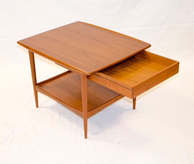 Danish teak end table would work well in-between a pair of chairs as it has a drawer feature that slides our both ways. Table has a Moreddi tag. Moreddi Company imported the first Danish furniture for Frank & Sons Furniture in southern California,