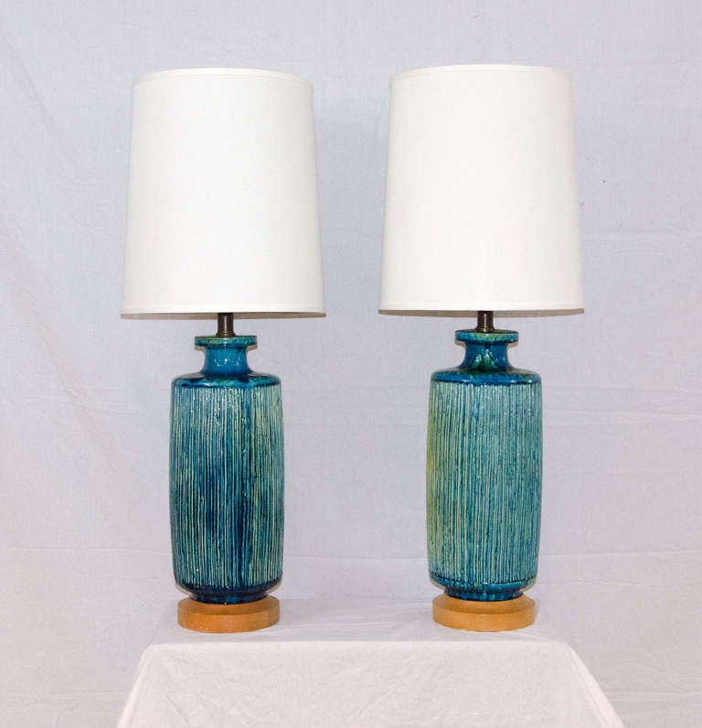 Gorgeous colors on these ceramic bases, blues, greens, and some splashes of yellow. Ceramic bases are attached to a circular blonde wood base. Nice large size.
Dimensions: base is 23
