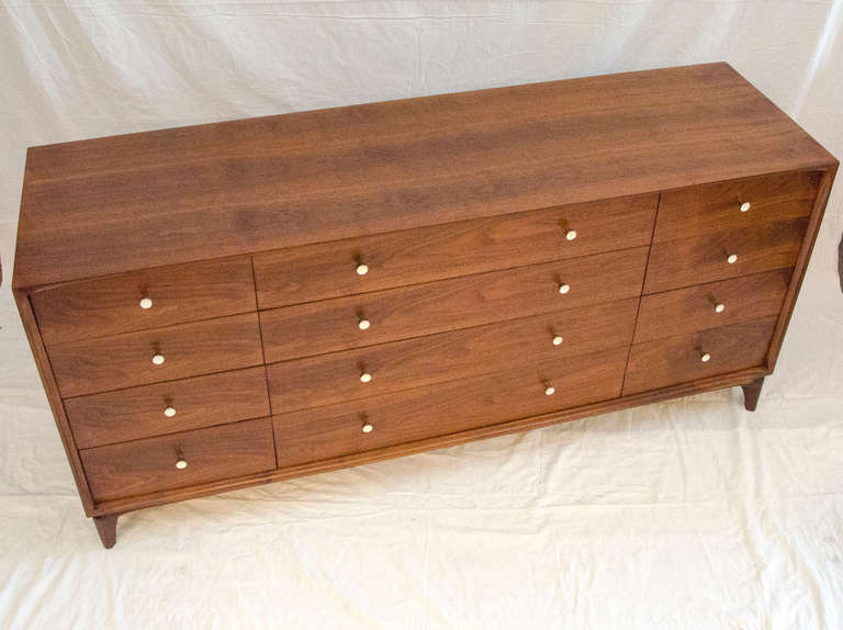 Spacious long walnut dresser with twelve drawers. Nice quality interior drawer construction using oak sides and mahogany drawer bottoms. Original drawer hardware. Leg height is 5 1/2