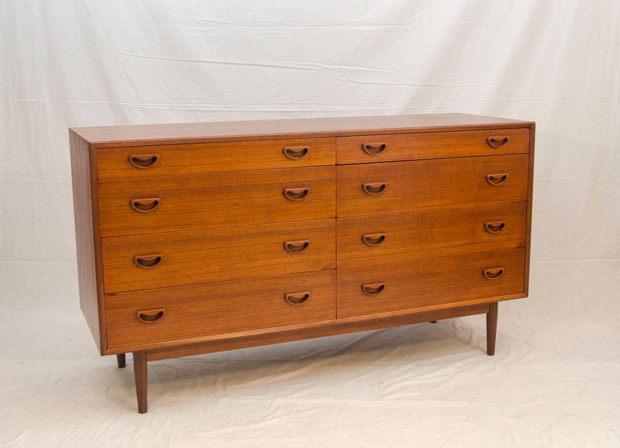 Very nice mid century Danish teak dresser with beech interior and a finished back. The top drawers are not as deep as the other six, so would be for socks and lingerie. The inset drawer pulls are very similar to the Peter Hvidt style. The dresser is