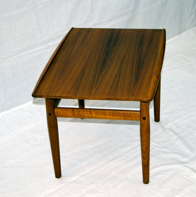 Mid Century Danish Teak end table. A wonderful accent next to a Danish Teak sofa or chair. Table top has an upturned edge feature on both sides. Retains the 