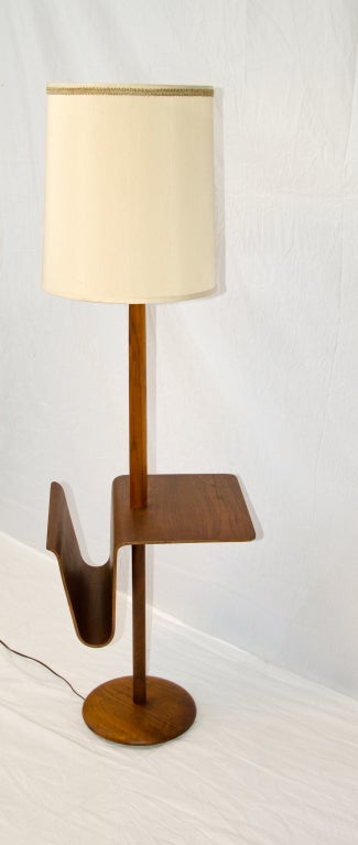Bent ply walnut magazine table incorporated with a floor lamp. Perfect next to a lounge chair for a reading lamp. Table height is 23