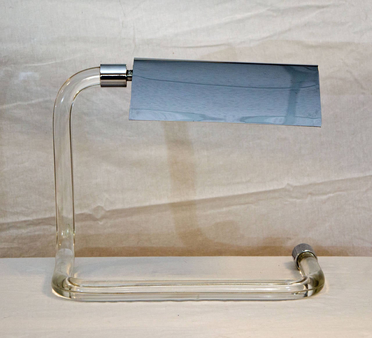 Very stylish mid century or Hollywood regency desk lamp designed by Peter Hamburger for Knoll. The cord is practically invisible inside the bent Lucite base. The swiveling chrome shade takes a tubular light bulb.