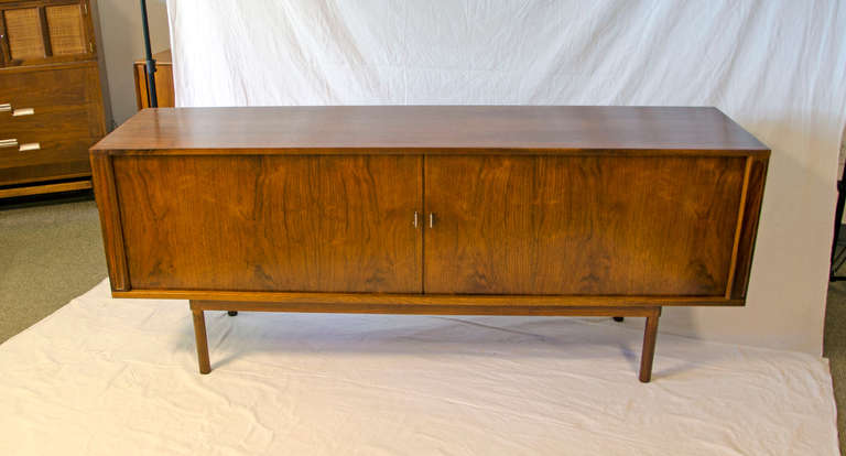 Very nice danish credenza in walnut with highly figured tambour doors, difficult to photograph clearly. Designed by Peter Lovig for Dansk. Retains tag on underside. Interior has five shallow storage drawers and adjustable shelves. The back finished