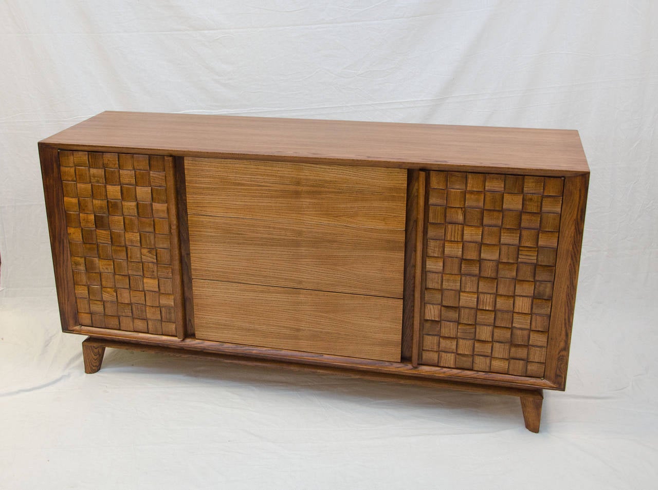 Very stylish buffet or credenza designed by Paul Laszlo and manufactured by Brown Saltman Co. Has three spacious drawers and two storage cabinets with woven block front doors and adjustable shelves. Retains the Brown Saltman painters palette decal.
