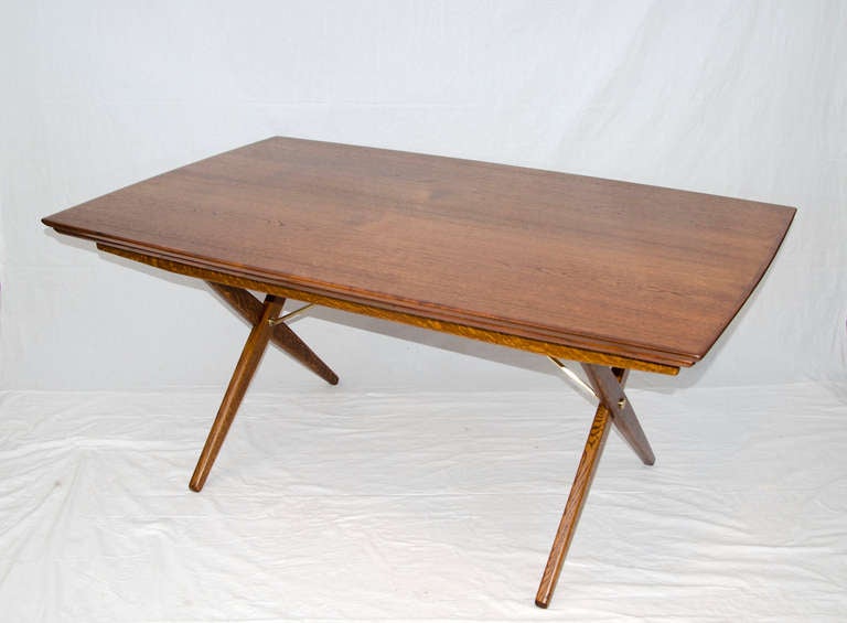 More unusual than the more generic teak tables with pull out leaves. This table is rectangular with a slight bowed out design, wider in middle than at the ends, 39