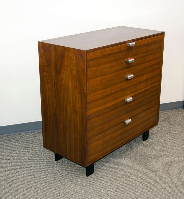 Very nice walnut chest of drawers manufactured by Herman Miller and designed by George Nelson. Top drawer handle marked with Herman Miller logo. Black legs.