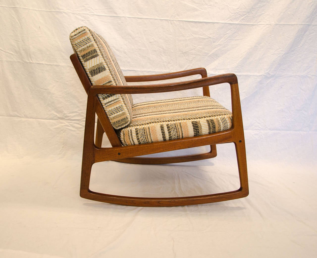 Nice rocking chair designed by Ole Wanscher for France & Sons and imported by John Stuart N.Y. Both circular tags are intact and attached to the frame behind the cushion.