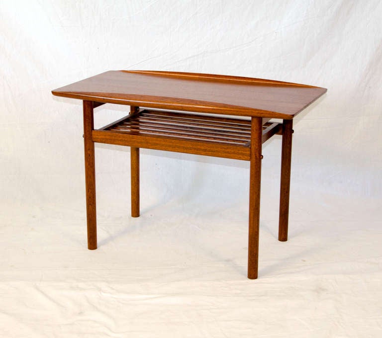 Nice occasional table with a shelf and upturned edges. Retains the 