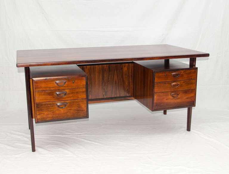 Beautiful danish rosewood desk with bookcase or display shelf on the front side.The desk would best display visible from all sides. Drawer interiors are beech. Very active book-matched rosewood grain patterns throughout. Chair pocket is 20 1/2