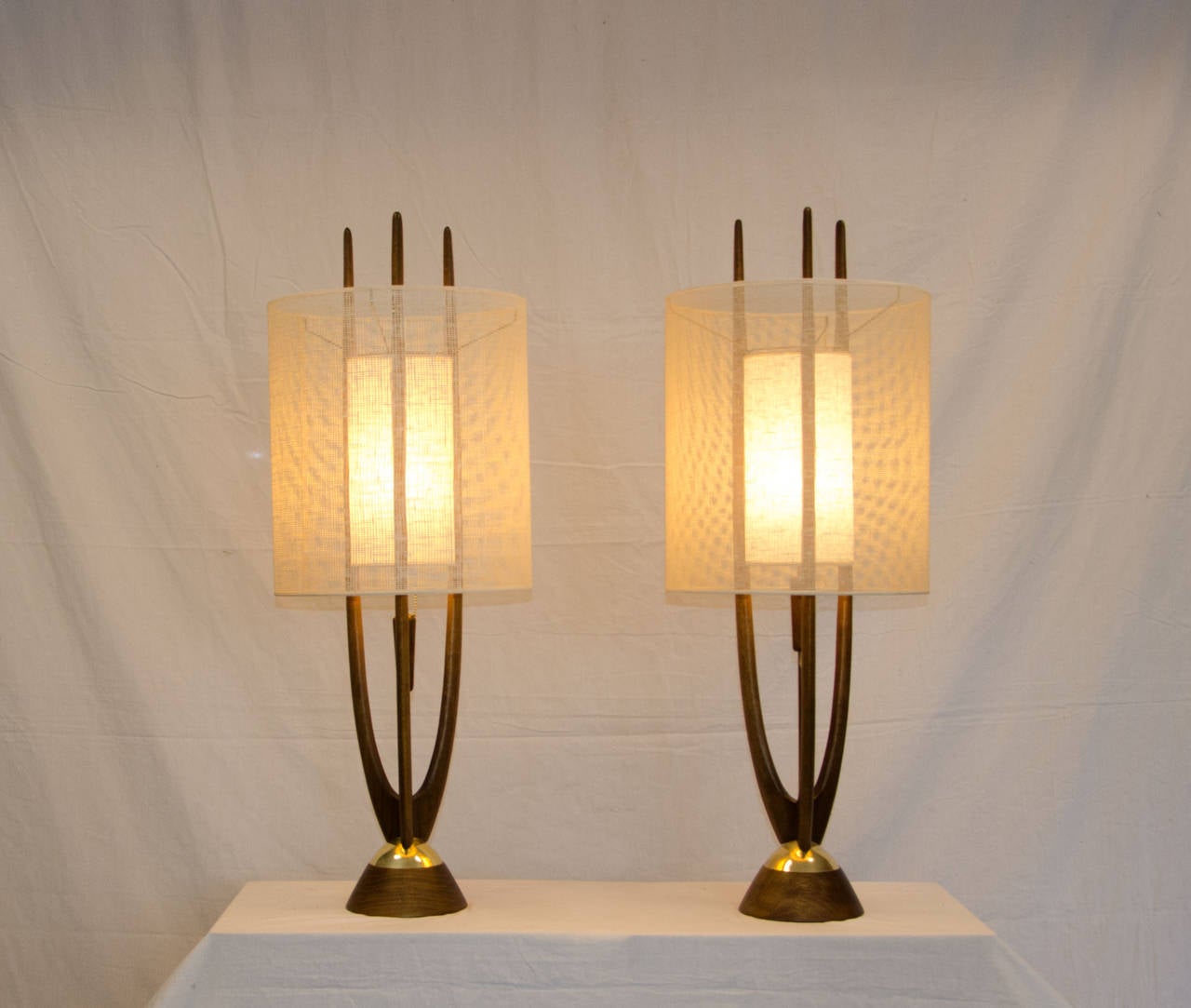 Very nice pair of Modeline lamps in original finish and with excellent original interior and exterior shades. The only minor difference is with the length of the small chain attached to the wooden pull in the center of the three wooden prongs. These