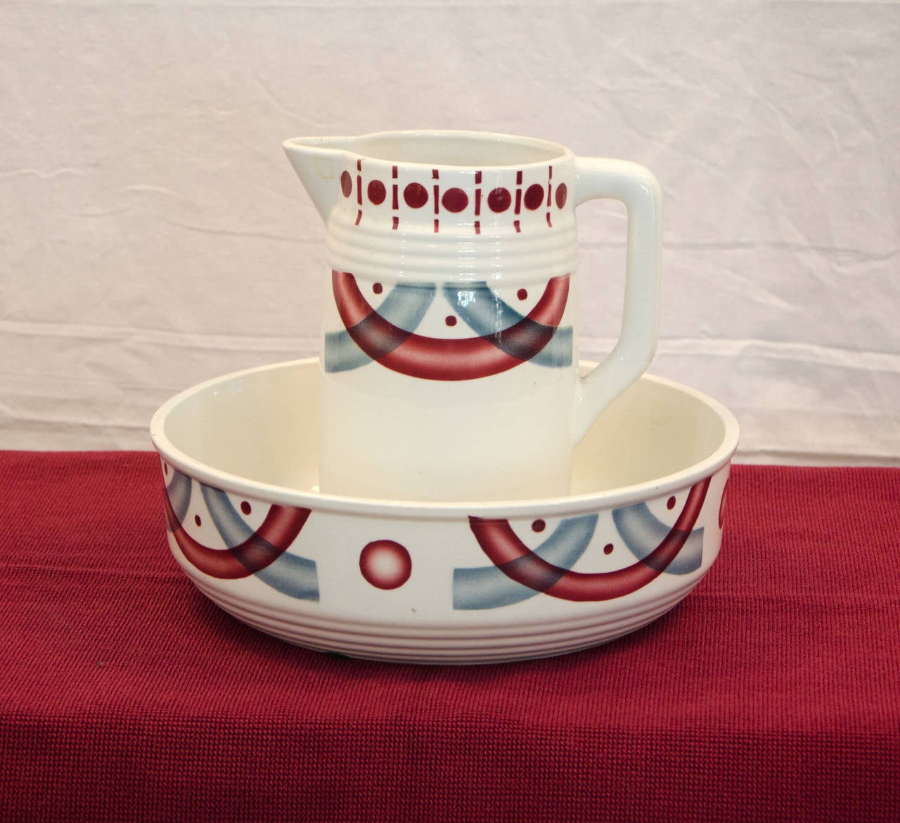 Czechoslovakian ceramic pitcher and bowl set with airbrushed  art deco pattern in a nice gray/blue and cranberry/red color combination. Was used as a washing vessel in bedroom when bathrooms were not as easily accessible.
The pitcher is 5