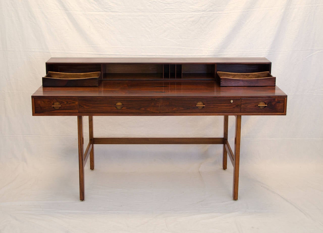 Rare desk in rosewood, designed by Jens Quistgaard for Peter Løvig Nielsen. Beautiful book-matched rosewood grain patterns throughout with mahogany drawer interiors. Lots of drawers and cubbyholes for storage, four drawers in main desk with nice