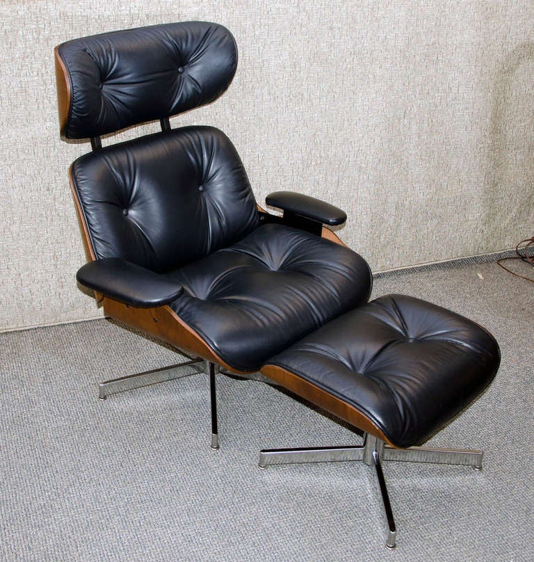 Vintage 1970's production Eames style lounge chair and ottoman. Five star chrome base, walnut bent ply frame and faux leather upholstery, ebonized wooden brackets attach headrest to back. Chair has some reclining capability, ottoman has a four star