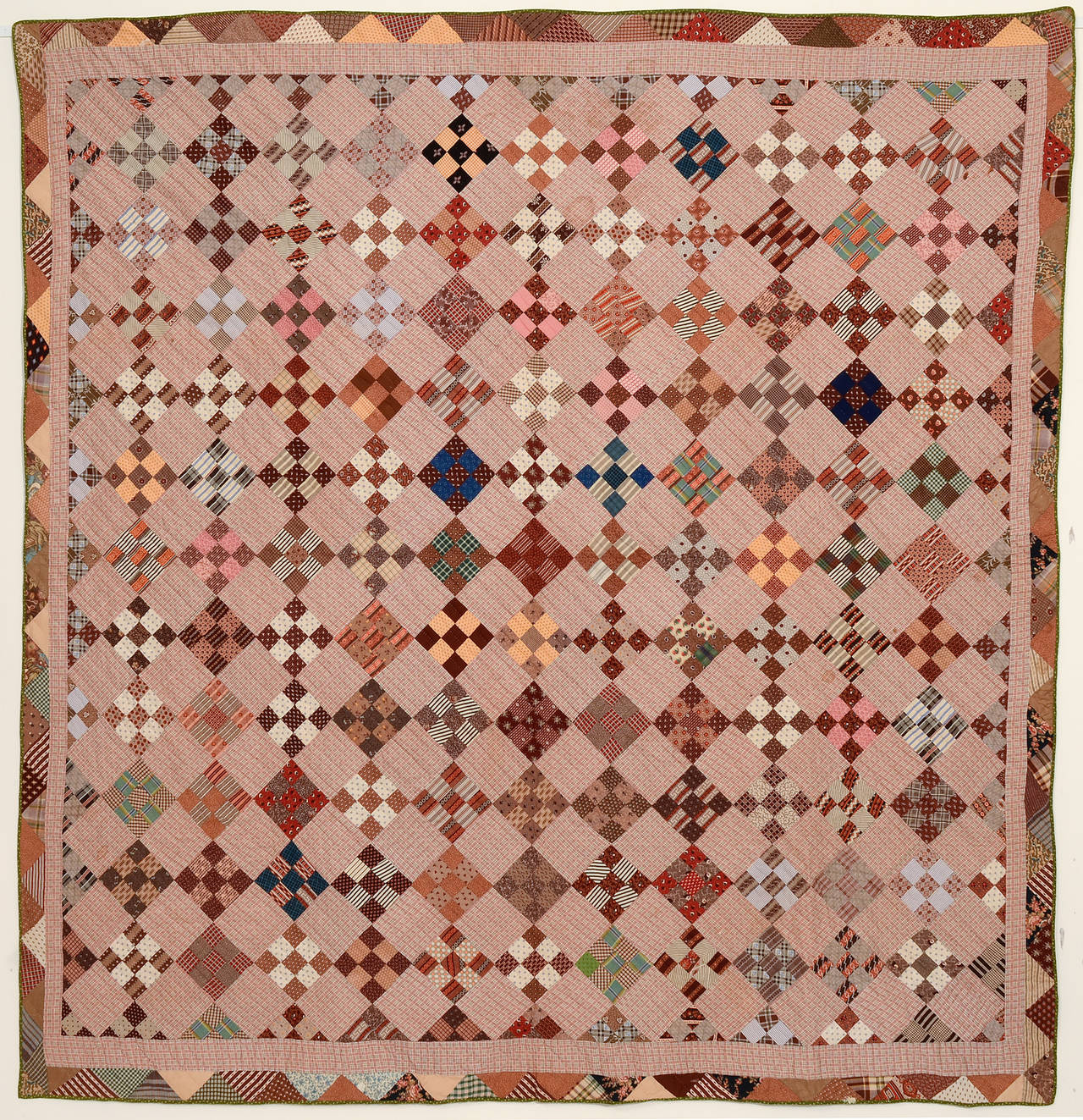 This nine-patch quilt is made of a fabulous grouping of late 19th century printed fabrics. The plaid off blocks are a nice extension of the nine-patch theme. Half blocks form a great inner border in addition to the triangles on the outside edge.