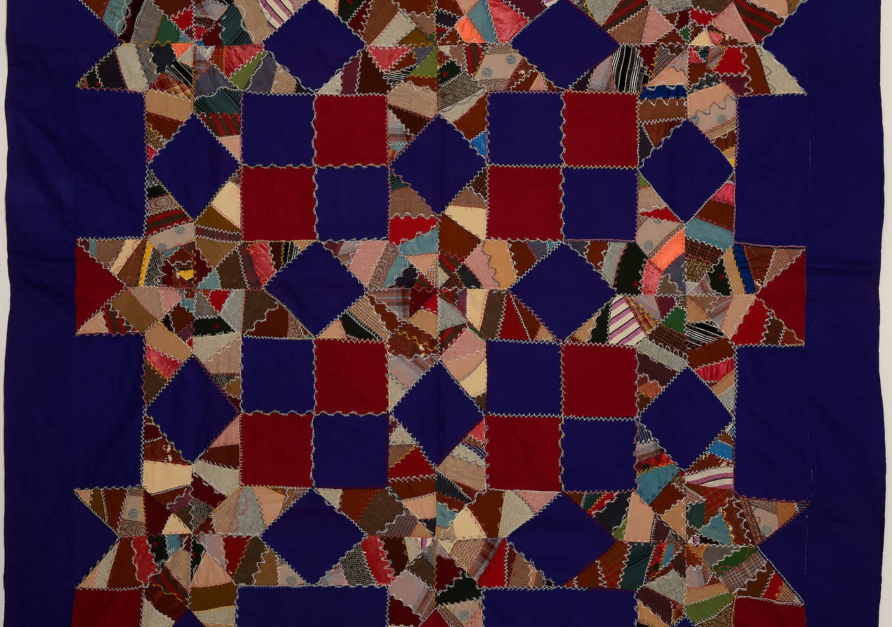 This Mennonite Touching Stars quilt clearly reflects the Victorian era in which it was made. The stars are made of totally irregular pieces similar to those used in Victorian Crazy quilts. It is all wool with a nice variety of embroidered stitching