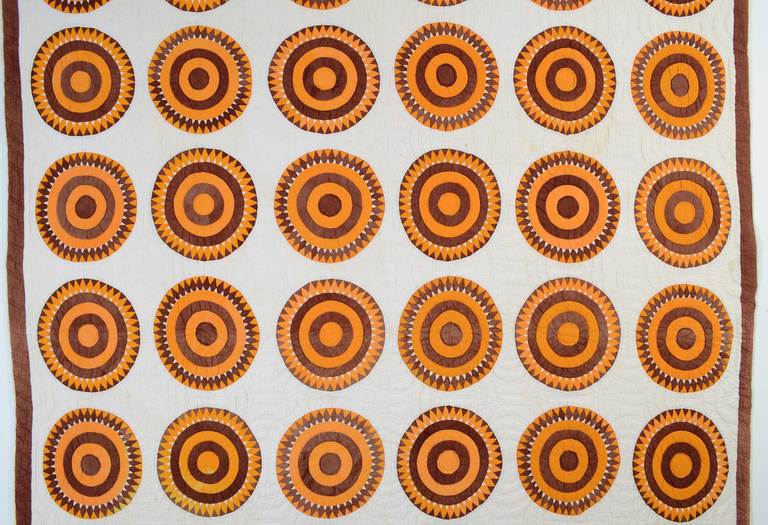 This Bull's Eye, or sawtooth circles, pattern is an unusual one. Solid colors add to the boldness of the pattern. The white areas are quilted with partial circles, carrying through the theme. It is in very good condition with some very slight