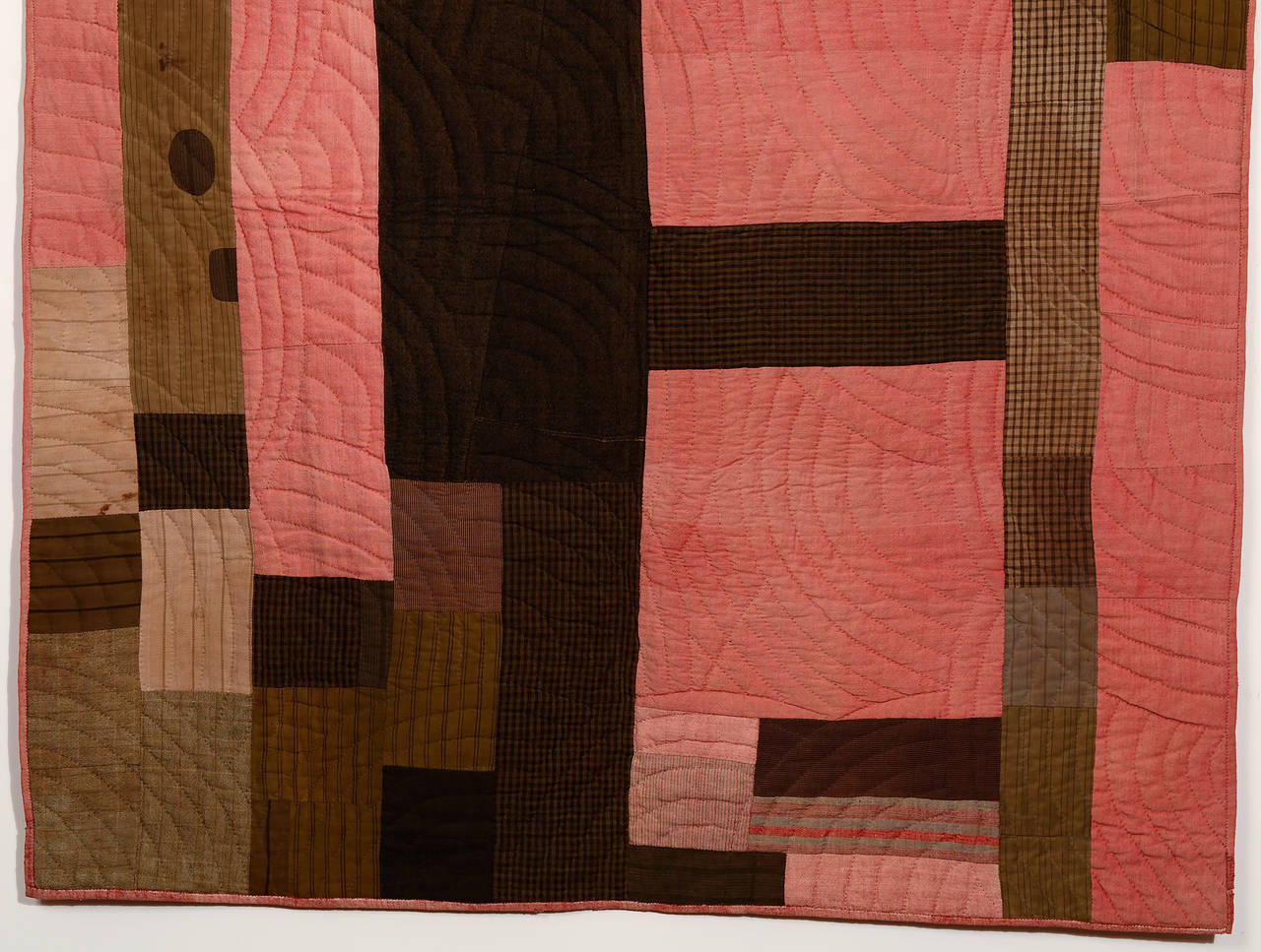 This early wool quilt truly looks like a fabric collage. It is made of a variety of probably homespun coarse wools of solid colors, plaids and stripes. The salmon fabric really pops out against the muted browns. It is quilted with concentric arcs.