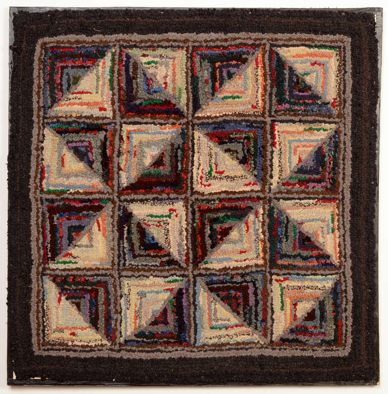 This hooked rug is made to look like the Log Cabin pattern usually associated with quilts. One can see this rug in several ways; there are five light and dark blocks; pinwheels and hourglasses. Lights and darks are well placed to give lots of