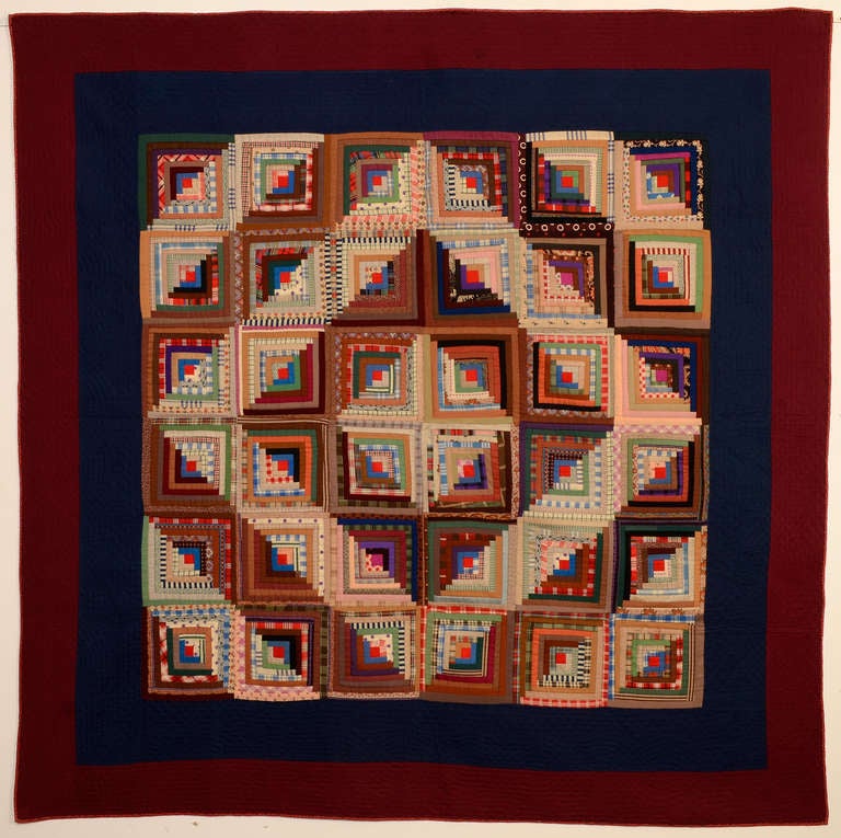 Finely crafted version of a classic Barnraising Log Cabin Quilt. Printed wool challis fabrics are beautifully combined to make the concentric diamonds pattern. Solid wools are used for the two borders that are quilted with cable patterns. They