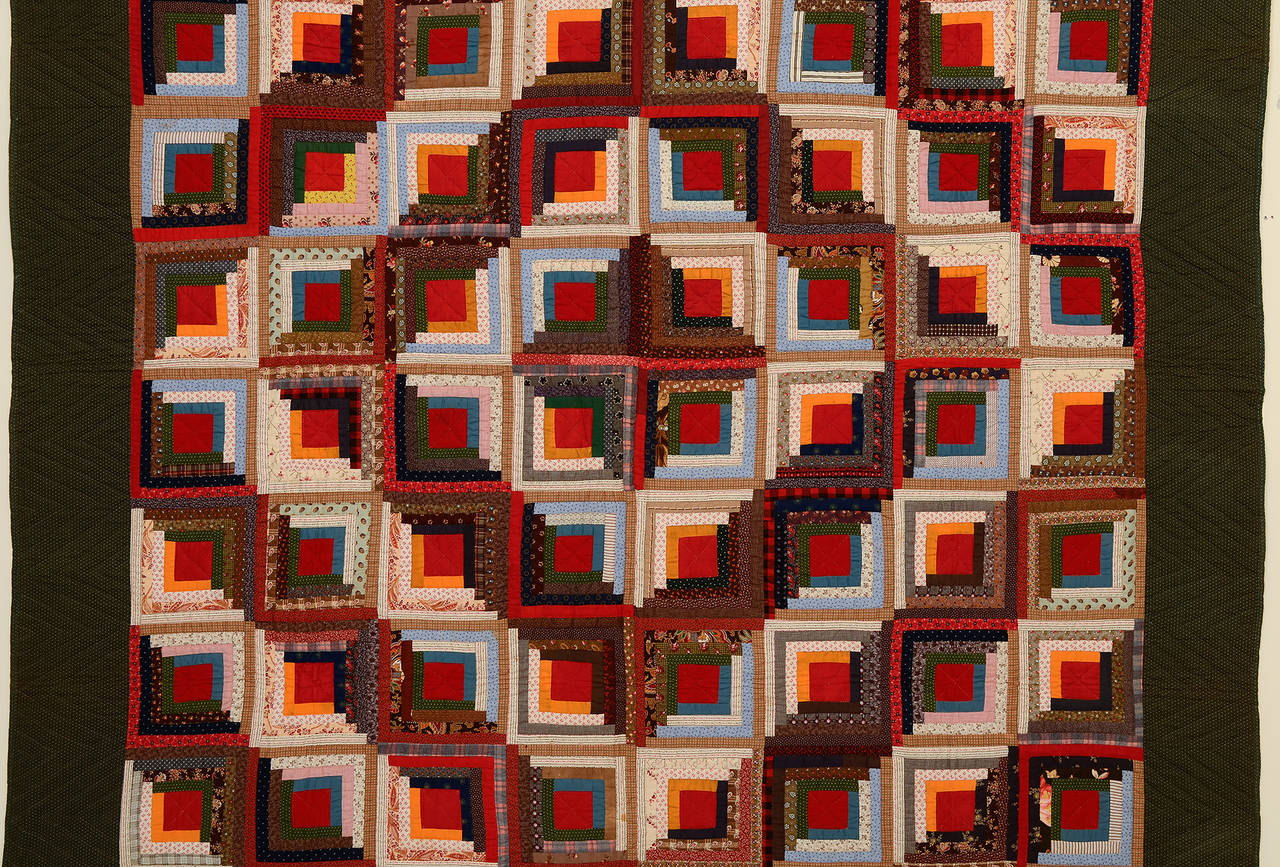 This wonderful barn raising log cabin quilt is an American Classic. Many people believe that the red centers represent the fireplace hearth.
The solid red centers of this quilt really pop against the calico prints. Measurements are 80
