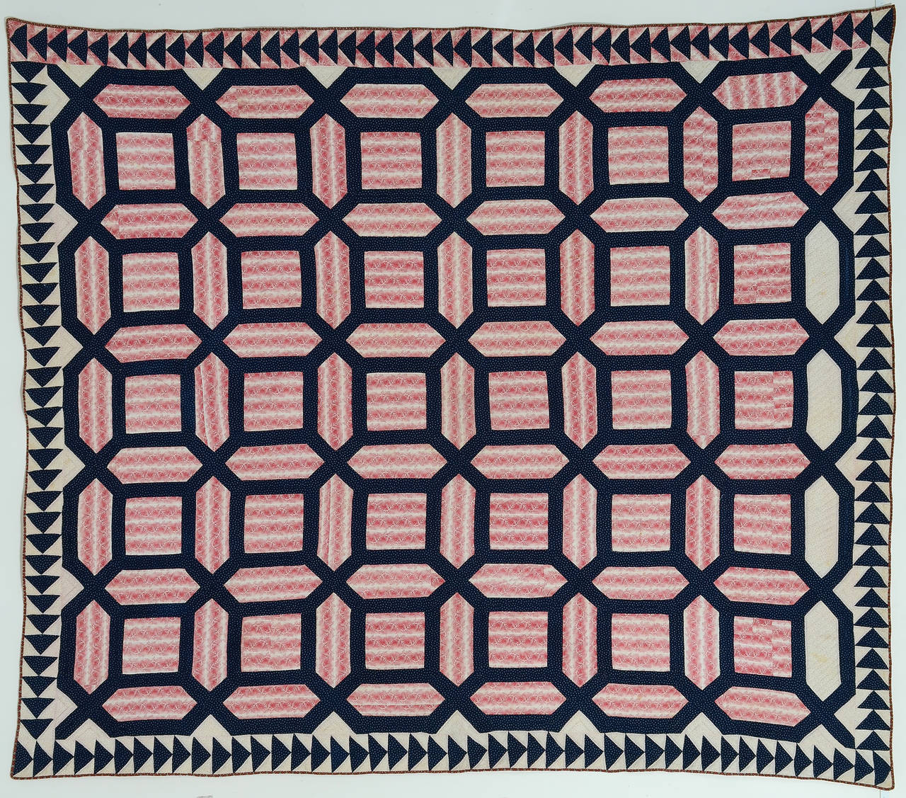 This early garden maze quilt is done with the richest of colors. The deep indigo is beautifully offset by the wonderful and unusual rose printed fabric. It is nicely quilted with circles in the center of each block. The wild goose chase border
