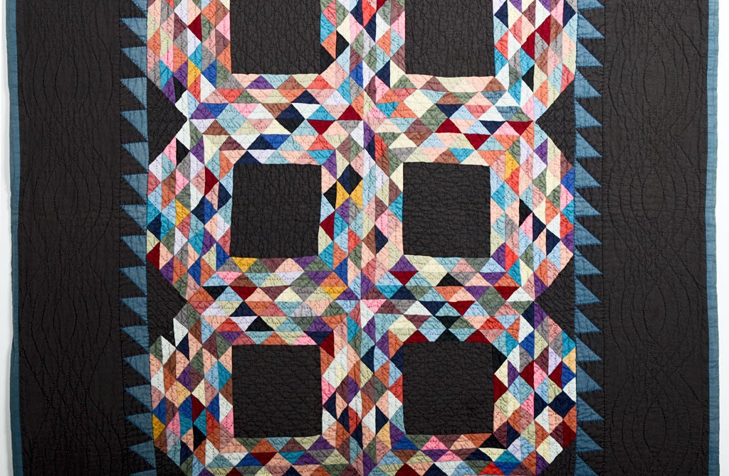 Dramatic Ohio Amish Ocean Waves Crib Quilt set on a black background. The wonderful jewel tones used for the small triangles really pop from the dark ground. Measures 42