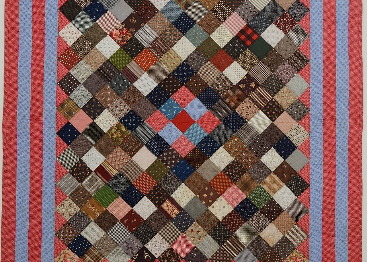 This one-patch charm quilt is more than its name. The blocks are set on point and colors are used to create a nine-patch center diamond. The term charm quilt refers to one in which no fabric is repeated. Many are very similar but on close