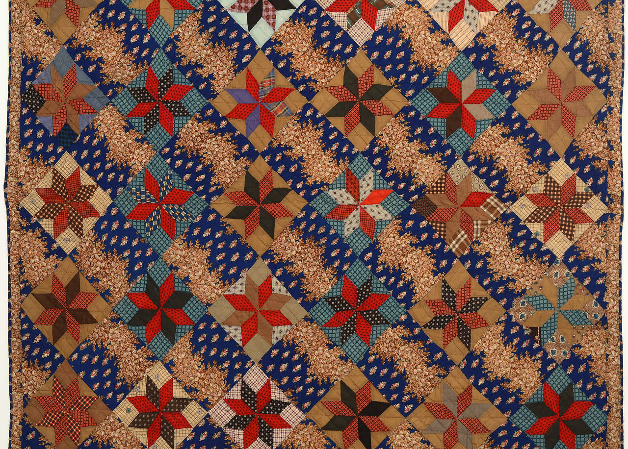 This richly colored LeMoyne stars quilt is made with fine wool challis on the front and back. The blue print of the off blocks is arranged so as to give the effect of diagonal lines throughout the quilt. Sewn to the quilt is a note that reads 