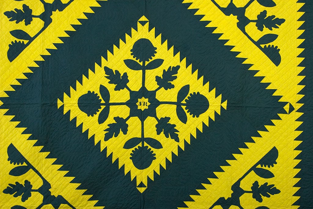 Vibrant and dynamic Mennonite Sawtooth Diamond Quilt with the unusual addition of applique patterns. Initials SR are reverse appliqued in the center. Nicely quilted with beautiful feather patterns in the dark green border and diamond. Superb