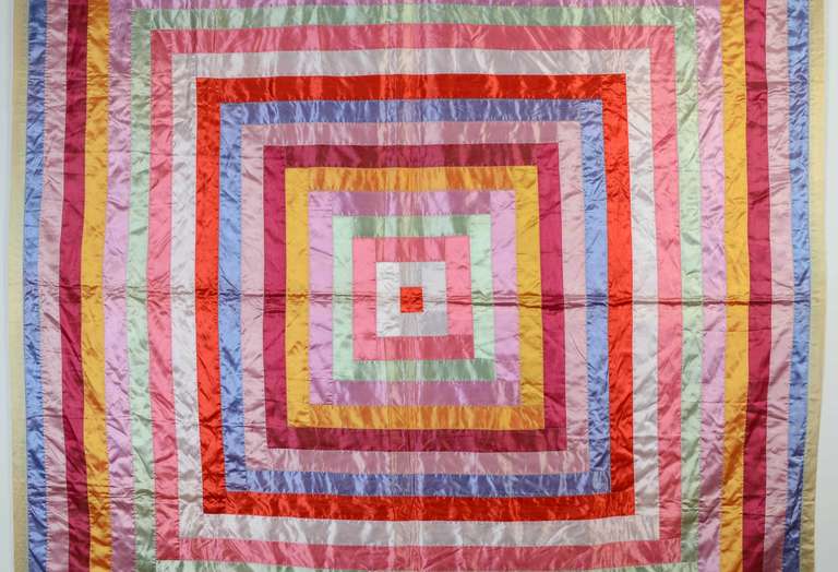 Sassy is the best description for this colorful Log Cabin Quilt. The  bold pattern is made even more so by the use of color and fabrics. It is made of wide strips of colorful satins. The backing is also an unusual choice of yellow damask linen.