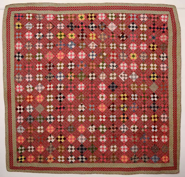 Nicely scaled classic Nine Patch quilt. It is made with a wonderful variety of late 19th century fabrics that are beautifully combined. An unusual red plaid in the off blocks cleverly echoes the Nine Patch pattern. The quilt is in pristine, un-used