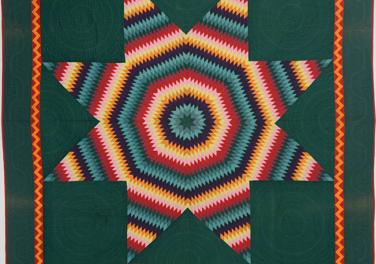 This Mennonite Lone Star quilt could not be richer in color. The deep green background perfectly sets off the white quilting which is elaborately done with wreaths. The diamond pieces making up the star are smaller than usual adding more waves of