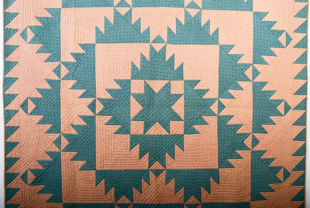 Wonderful version of the strong Delectable Mountains Quilt done in a palette of unusual, gentle colors. The Variable Star center and extra triangles next to the sawtooth border are unusual touches. Measures 82
