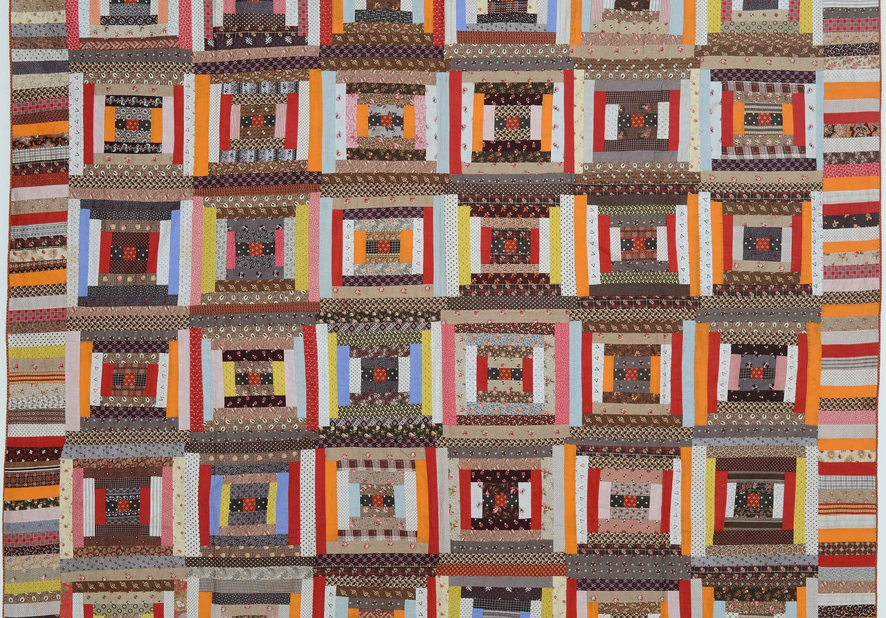 Klassischer Gerichtsstufen-Blockhaus-Quilt mit einer guten Verwendung von hellen und dunklen Bereichen. Einfarbige rote und orangefarbene Stämme stehen im Kontrast zu den bedruckten Stoffen. Ausgezeichneter Zustand. Es ist leicht und hat keine