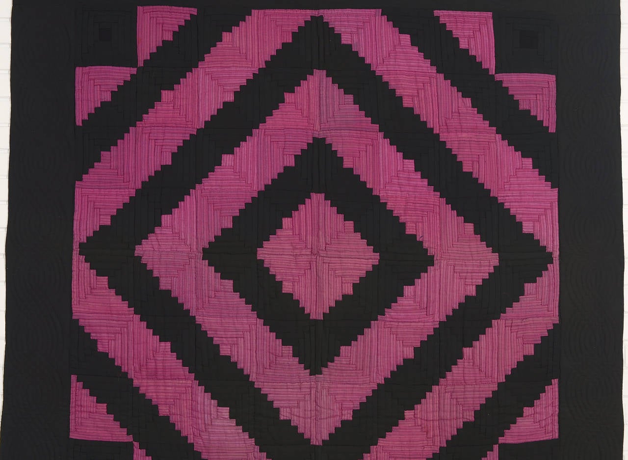 While the barnraising log cabin is a very quilt traditional pattern, this example looks far more modern than one expects from the late 19th century when it was made. The magenta fabric has a thin black stripe that perfectly ties in with the solid