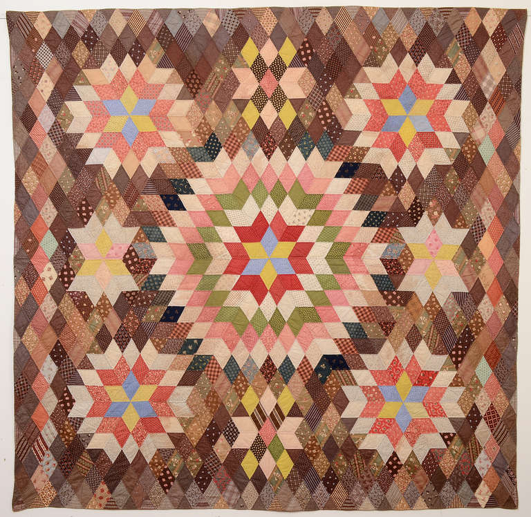 This unusual Starbursts quilt is especially complex because of the pieced diamonds background. Five starbursts and four other geometric elements seem to float upon it. It is made of a wide variety of late 19th century fabrics that are well blended.