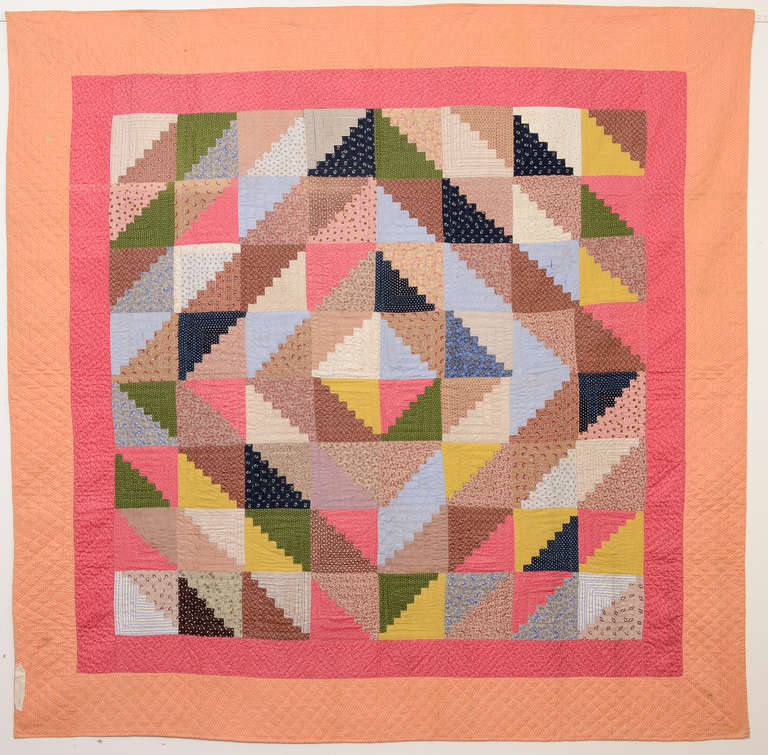 This classic Barnraising Log Cabin Quilt was made with an unusual color palette. The calico prints are typical of late 19th century Pennsylvania but they are put together in an overall lighter tone than one usually sees. It is in excellent, unwashed