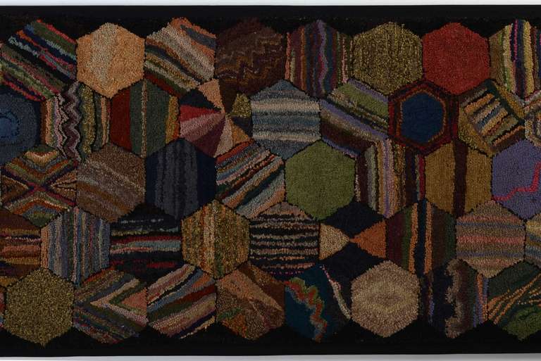 Unusual hooked rug of hexagons filled in with a variety of patterns. It is made of wools; circa 1920. Mounted on a stretcher and ready to be hung either horizontally or vertically. The stretcher is 36
