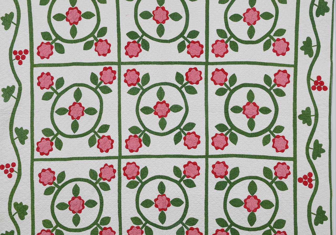 This lovely floral wreaths quilt has many traditional elements yet shows its own unique personality. The repetition of the flower in the center of the wreath is an unusual variation. Berries or grapes in the border with a leaf different from the